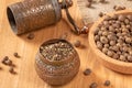 Rustic black pepper mill and whole peppercorns on wooden background Royalty Free Stock Photo