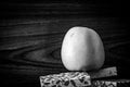 Rustic black and white image of an apple on a stack of tiles on with a wooden background