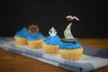 Rustic blue iced cup cakes with mini boat decorations