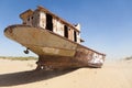 Rustic boats on a ship graveyards on a desert around Moynaq, Muynak or Moynoq - Aral sea or Aral lake - Uzbekistan in Central Asia Royalty Free Stock Photo