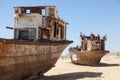 Rustic boats on a ship graveyards on a desert around Moynaq, Muynak or Moynoq - Aral sea or Aral lake - Uzbekistan in Central Asia Royalty Free Stock Photo
