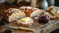 A rustic breadboard with fresh sourdough, butter, and a pot of jam Royalty Free Stock Photo