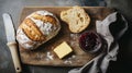 A rustic breadboard with fresh sourdough, butter, and a pot of jam Royalty Free Stock Photo