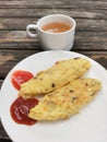 Rustic breakfast composition featuring omelets, ketchup and a cup of tea on wooden surface Royalty Free Stock Photo