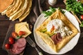 Rustic breakfast: crepe galette, poached egg, ham, avocado and cheese