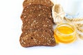 Rustic breakfast on a light wooden background - sliced bread with seeds, ears of wheat. straw wicker shoes. cup with honey Royalty Free Stock Photo