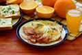 Rustic breakfast - roasted bread with butter and chives, fried eggs and bacon.