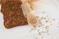 Rustic breakfast on a wooden background - sliced bread, seeds on a spoon, ears of wheat Royalty Free Stock Photo