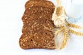 Rustic breakfast on a wooden background - sliced bread with seeds, seeds on a spoon, ears of wheat, wicker shoe and a Royalty Free Stock Photo