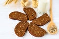 Rustic breakfast on a wooden background - sliced bread with seeds, sunflower seeds on a spoon, ears of wheat and a glass Royalty Free Stock Photo