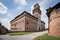 Rustic brick structure situated in a scenic Italian castle grounds, surrounded by lush greenery