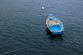 Rustic, bright blue rowboat anchored at sea Royalty Free Stock Photo