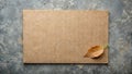 A rustic brown paper sheet with a single dried leaf on weathered stone. Generative AI Royalty Free Stock Photo