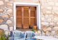 Rustic brown wooden window shutters with old stone wall background. Royalty Free Stock Photo