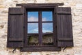 Rustic brown wooden window shutters with old stone wall background. Royalty Free Stock Photo