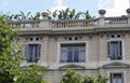 Rustic building with ornate balconies, plants and trees