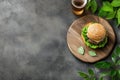 Rustic burger and beer setup with fresh greenery on wooden table Royalty Free Stock Photo