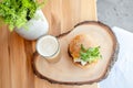 Rustic burger and beer setup with fresh greenery on wooden table Royalty Free Stock Photo