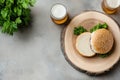 Rustic burger and beer setup with fresh greenery on wooden table Royalty Free Stock Photo