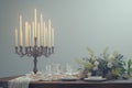 A rustic candlelit dinner setting featuring an antique wooden table set against a stark white background