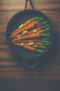 Rustic carrots in a pan on wood Royalty Free Stock Photo