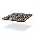A rustic cast iron trivet with ornate design Royalty Free Stock Photo