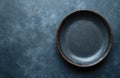 Rustic ceramic plate with mottled blue surface. Dark teal, grey background grainy, speckled stoneware texture. Simple, clean, Royalty Free Stock Photo