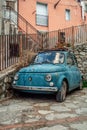 Rustic Charm in Rocca Imperiale: Vintage Blue Fiat 500 Abandoned on Stone Street