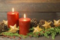 Rustic Christmas background with red burning candles and gold stars Royalty Free Stock Photo