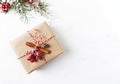 Rustic Christmas gift box with Christmas decorations on white wooden background. Flatlay. Copy space