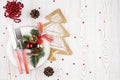 Rustic Christmas table with festive decor, cutlery on a white plate, glass, cones, fir branches on a white washed background, flat Royalty Free Stock Photo