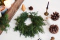 Rustic christmas wreath with candles, pine cones, thread and ornaments on white  table Royalty Free Stock Photo