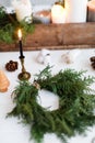 Rustic christmas wreath with candles, pine cones, thread and ornaments on white  table Royalty Free Stock Photo
