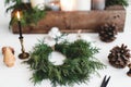 Rustic christmas wreath with candles, pine cones, thread and ornaments on white  table Royalty Free Stock Photo