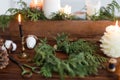 Rustic christmas wreath with candles, pine cones, thread and ornaments on wooden table Royalty Free Stock Photo