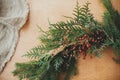 Rustic Christmas wreath detail closeup. Fir branches, pine cones, berries on wooden table. Authentic stylish still life. Making Royalty Free Stock Photo