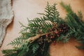 Rustic Christmas wreath detail closeup. Fir branches, pine cones, thread, berries, cinnamon on wooden table. Authentic stylish Royalty Free Stock Photo