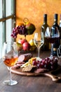 A rustic colourful arrangement of wine with a meat and cheese charcuterie board.