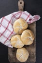 Rustic composition of the Kaiser rolls. A crusty round bread rolls on a linen kitchen cloth and a wooden cutting board Royalty Free Stock Photo