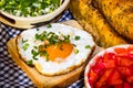 Rustic composition with sausages rolls, fried egg on toast bread, different bowls with sauce and chopped vegetables Royalty Free Stock Photo