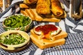 Rustic composition with sausages rolls, fried egg on toast bread, different bowls with sauce and chopped vegetables Royalty Free Stock Photo