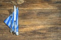 Rustic cutlery with napkin at bavarian pattern on old wooden table.