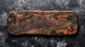 Rustic dark brown wooden rectangular cutting board on a dark gray textured surface Royalty Free Stock Photo