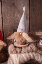 Rustic decoraton with handmade interior toy gnome, candle and warm knitted scarf on brown wooden background, perfect for scandi Royalty Free Stock Photo