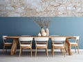 Rustic dining table and white chairs against of blue stucco wall with wooden slab as wall decor. Interior design of dining room Royalty Free Stock Photo