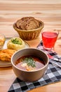 Rustic dinner - chicken fillet in breading, mashed potato and pickle cabbage with saltwort soup, brown bread and a glass of Royalty Free Stock Photo