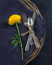 Rustic dinner setting with with a yellow flower