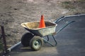 rustic dirty construction wheelbarrow with push broom on the street
