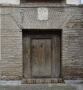 Rustic door in brick facade with family emblem