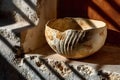 Rustic Earthenware Bowl on Textured Stone Shelf - Ideal for Design and Decor Projects Generative AI Royalty Free Stock Photo
